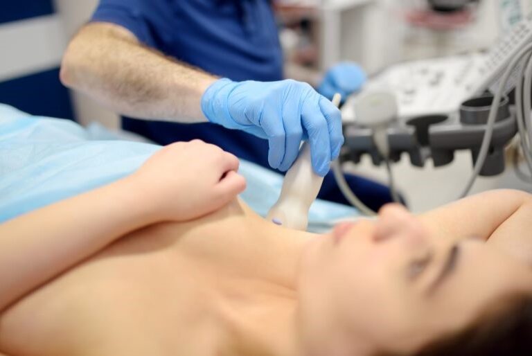 Arzt führt Ultraschalluntersuchung der Lymphknoten zur Brustkrebsdiagnostik bei einer Patientin durch.