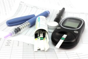 Blutzuckermessgerät, Teststreifen und Insulin-Pen auf Tabelle für Diabetes-Management.